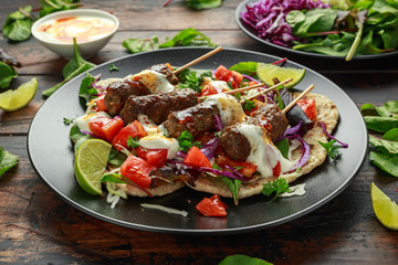 Lamb mint kebabs with flatbread, mix of vegetables, lime and greek yoghurt chilli sauce