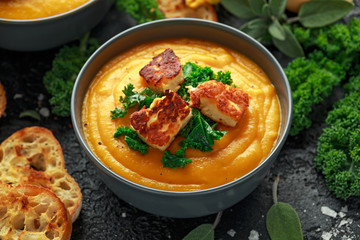Baked butternut squash and carrot cream soup with steamed kale and fried halluomi