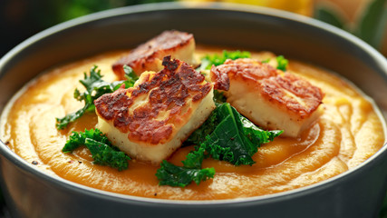 Baked butternut squash and carrot cream soup with steamed kale and fried halluomi