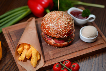 burger with french fries on a wooden board