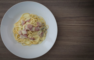 Spaghetti carbonara on wood table.