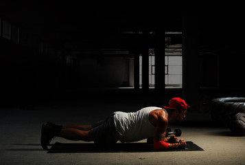 Fototapeta na wymiar Athlete is engaged in crossfit in brutal gym