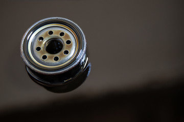 Used oil filter stands in old oil. The process of replacing the engine oil in a car
