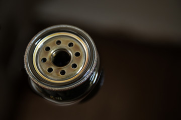 Used oil filter stands in old oil. The process of replacing the engine oil in a car