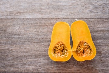 cut the pumpkin in half on a wooden background texture