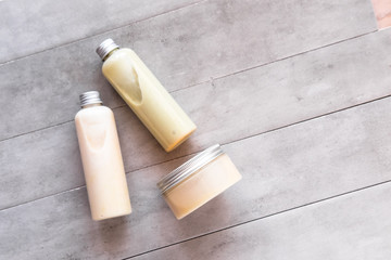 Bottles with spa cosmetic products from above on gray concrete table. Beauty blogger, salon treatments concept. Minimalism