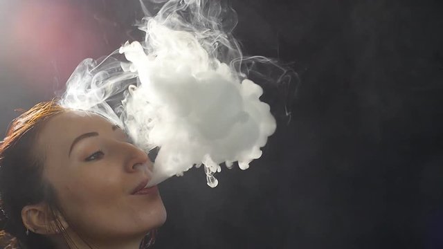 Young woman smoke an electronic cigarette.