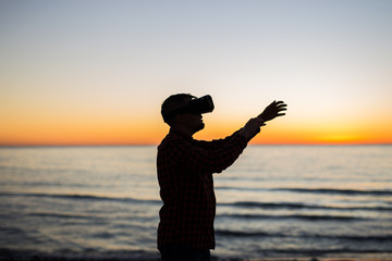 Man using virtual reality glasses on over beautiful sky and sea background