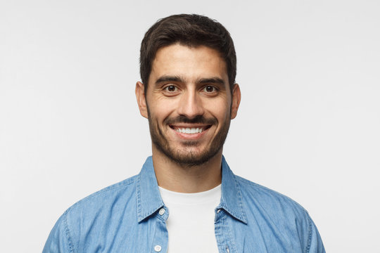 Smiling handsome man in blue shirt isolated on gray background
