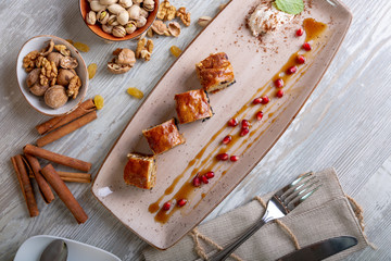 Close up view of beautiful elegant eastern sweets, baklava, served on the plate. Beautiful decoration, restaurant dish, ready to eat. Tea time, cozy atmosphere.