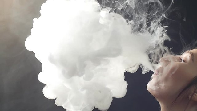 Young woman smoke an electronic cigarette.
