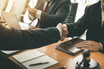 Businessman shaking hands to seal a deal with his partner lawyers or attorneys discussing a contract agreement - obrazy, fototapety, plakaty