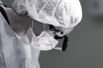 female surgeon doctor wearing protective mask and hat during the operation. Healthcare, medical...