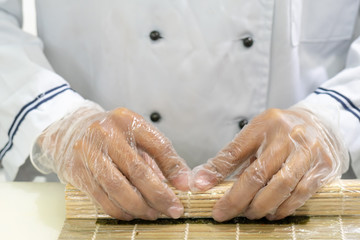 Preparation of sushi. Hands of the cook.