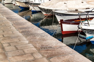 Small fishing boats in the harbor. Detail on the bow of the boat. Tied boats in the harbor. Port on the island of Hvar. © martinfredy