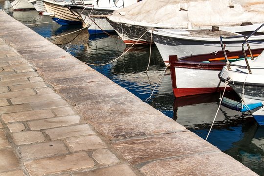 Small fishing boats in the harbor. Detail on the bow of the boat. Tied boats in the harbor. Port on the island of Hvar.