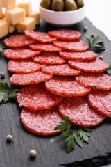 delicious sliced salami on a stone plate white background