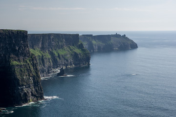Landscape view of Cliffs of Moher and dark blue sea on clear sunny day. County Clare, Ireland.