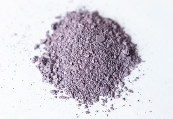 Natural colored pigment powder close up, matt pastel lilac eyeshadow or powder mica pigment on a white background