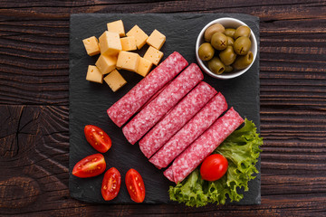 delicious sliced salami on a stone plate wooden background