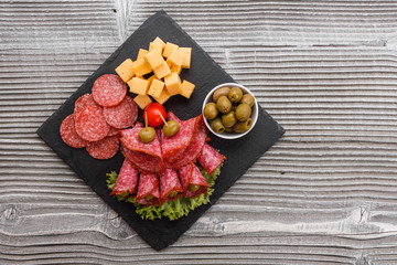 delicious sliced salami on a stone plate wooden background