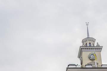 Ukrainian city hall high tower with national coat of arms on gray sky in rainy day time empty space...