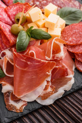 Cold smoked meat plate on a rustic wooden background
