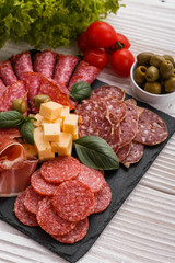 Cold smoked meat plate on a rustic wooden background