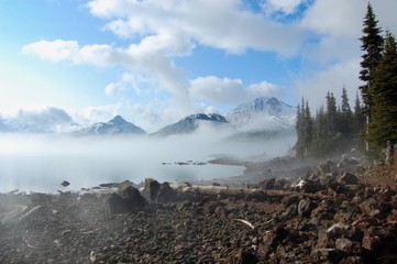 The scenery in British Columbia contains spectacular glacier mountains, lakes and forests. This partially cloudy morning brought about a light cloud cover over Garibaldi Lake.