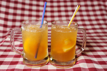 two glasses of beer cocktails with orange close-up on checkered fabric