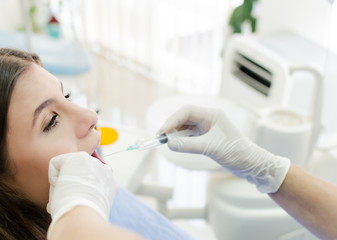 Dentist giving anesthesia to her patient