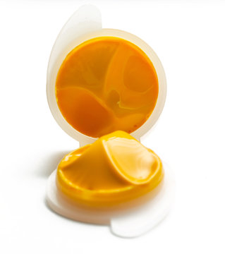 Orange paint in a plastic container isolated on white background

