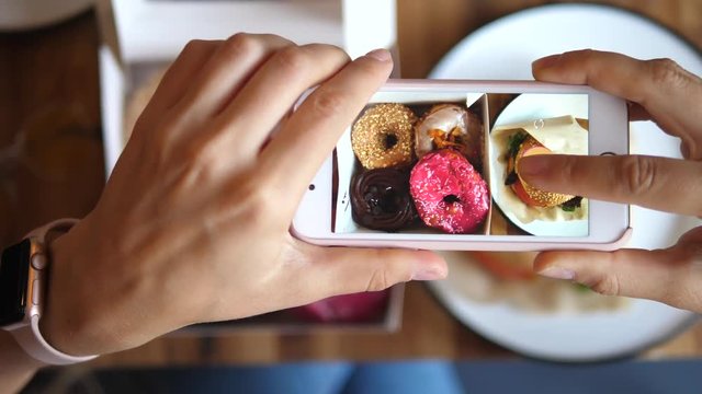 Woman Hands Taking Photo Of Food By Mobile Phone. Food Photography Of Donuts.