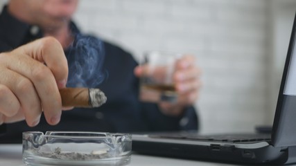 Businessman Blurred Image Drinking Whisky and Smoking a Cigar