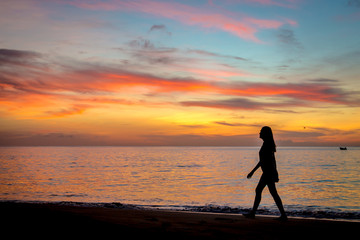 Woman walking in a colorful sunset in Caribe