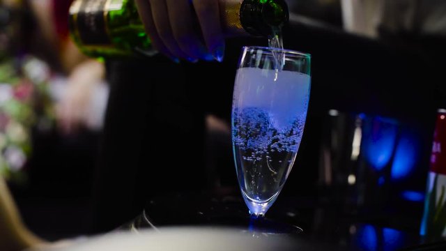 Lesbian wedding. Inside the wedding limousine. Close up female hand pouring champagne wineglass