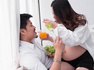 Pregnancy healthy food and people concept.future dad and mom eating healthy salad and take care together.
