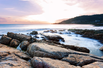 Long exposure image of Dramatic sky seascape with rock in sunset scenery background.
