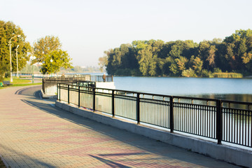 city river waterfront district space for walking with black fence and empty paved road