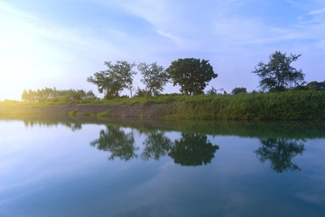 Fototapeta na wymiar The beautiful lake when sunshine blue sky and sunset with tree reflection.