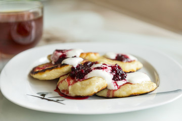 Pancakes with lingonberry cream sauce on a plate