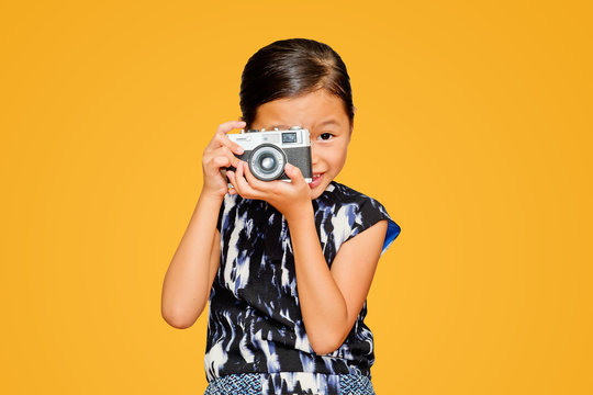 Beautiful smiling girl holding a camera. 