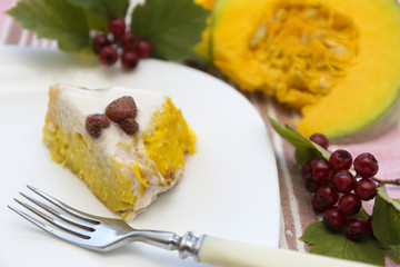 Piece of pumpkin homemade cheesecake with white cream. Thanksgiving day food.