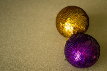Two christmas balls for tree isolated on gold background. Violet, gold New year decorations.
