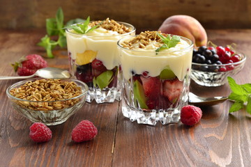 Dessert with fresh berries, granola and custard in glasses