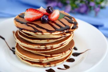 Pancakes with berries and chocolate syrup