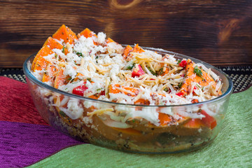 Vegetarian dish of orange pumkin, mixed vegetables, herbs and cheese