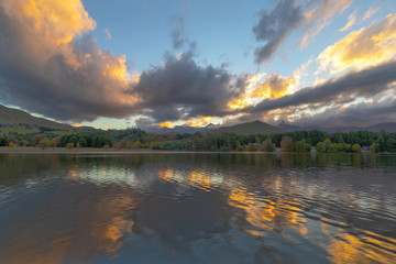 Yellow colored clouds and autumn trees