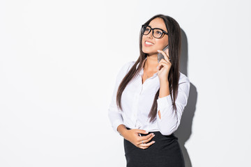 Young businesswoman walking talking on mobile phone, isolated on white background