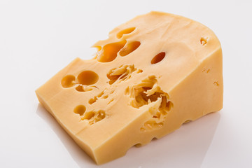 Piece and slices of cheese on a white background